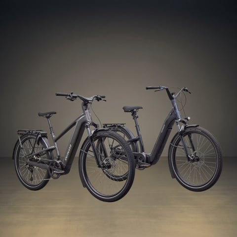 Three modern hybrid bicycles displayed against a neutral background, featuring step-through frames and disc brakes