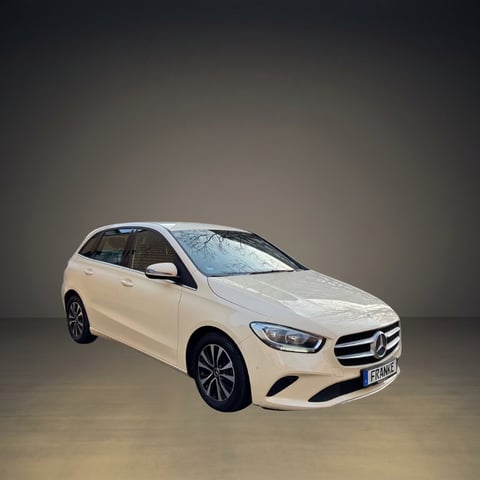 White Mercedes-Benz B-Class hatchback vehicle displayed against a neutral gray background studio setting