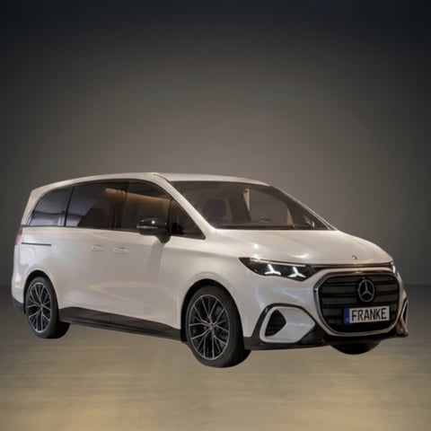 White Mercedes-Benz electric minivan photographed against a neutral gray background