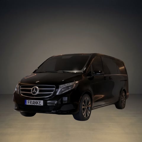 Black Mercedes-Benz minivan with FRANKE license plate displayed against a neutral gray background studio setting